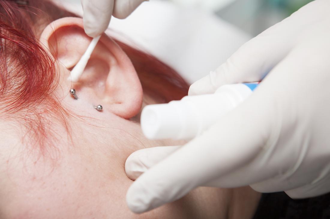tragus-piercing-being-cleaned-with-cotton-bud-and-liquid.